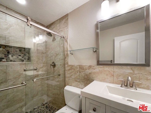 bathroom featuring an enclosed shower, vanity, toilet, and tasteful backsplash