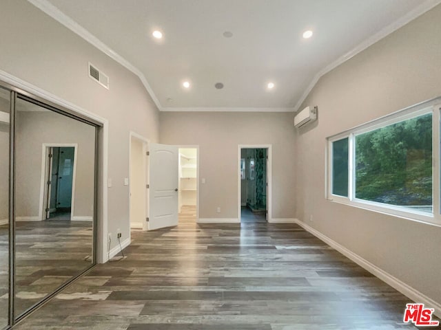 empty room with ornamental molding, dark wood-type flooring, and a wall unit AC