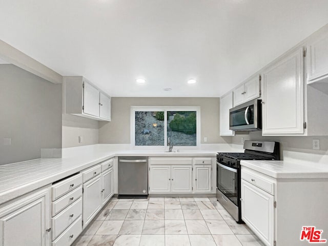 kitchen with white cabinetry, sink, and stainless steel appliances