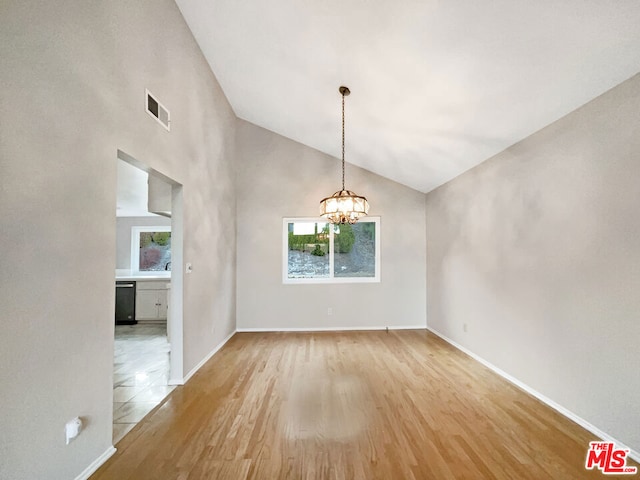 unfurnished dining area featuring high vaulted ceiling, light hardwood / wood-style floors, and an inviting chandelier