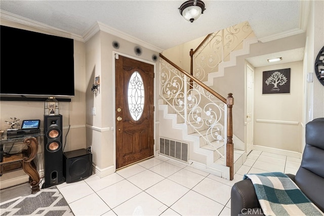 entryway featuring a textured ceiling, light tile patterned flooring, and crown molding