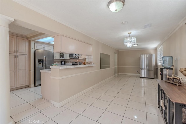 kitchen featuring backsplash, crown molding, light tile patterned floors, kitchen peninsula, and stainless steel appliances