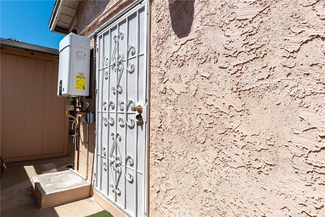 view of exterior entry featuring tankless water heater