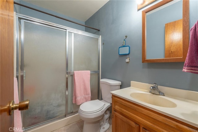 bathroom with tile patterned flooring, vanity, a shower with door, and toilet