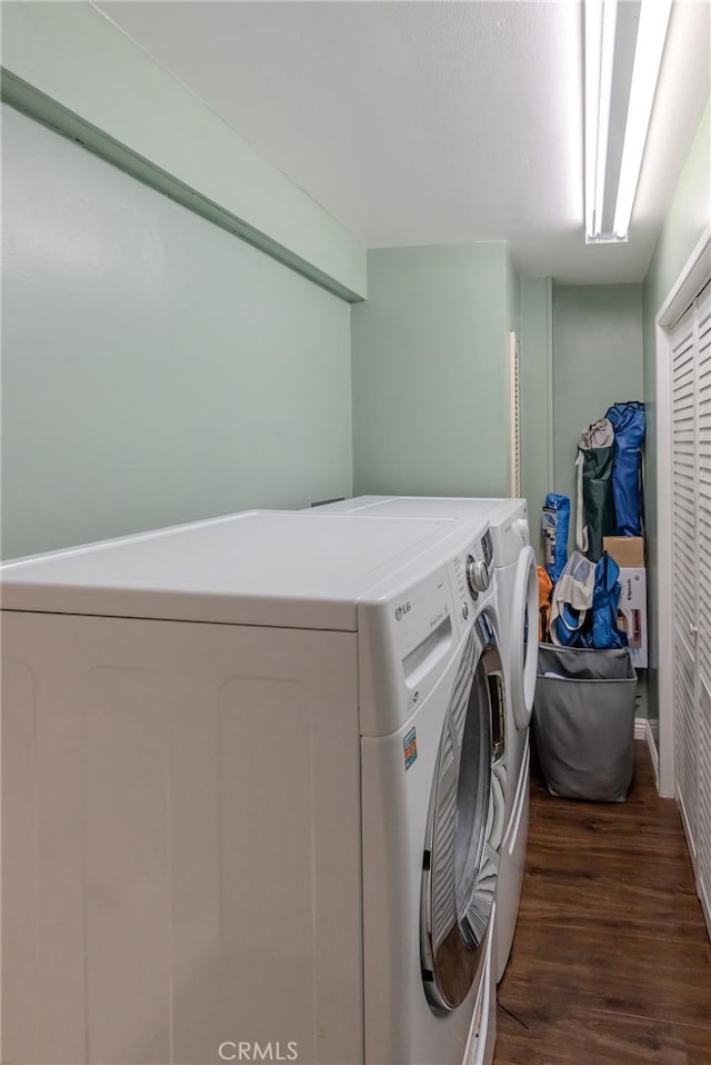 laundry area with washer and clothes dryer and dark hardwood / wood-style floors