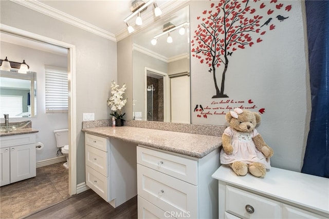 bathroom with hardwood / wood-style floors, vanity, toilet, and crown molding