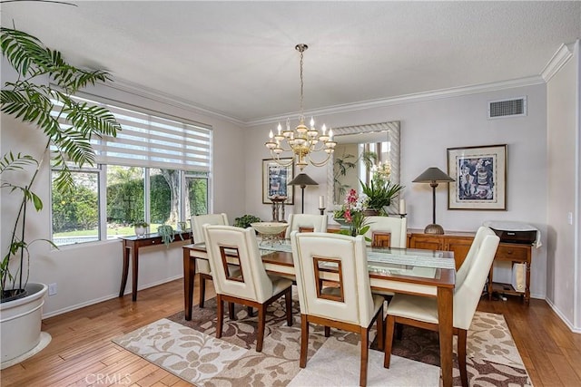 dining area featuring crown molding, hardwood / wood-style floors, and a chandelier