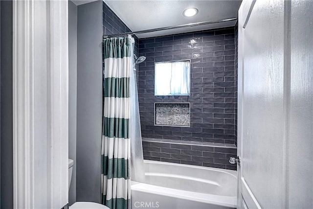 bathroom with toilet and shower / bath combo with shower curtain