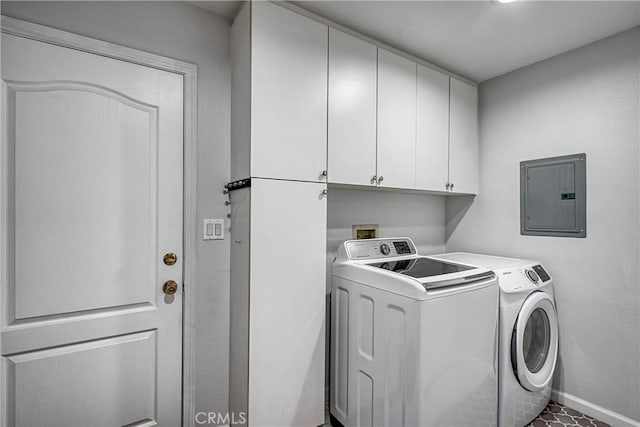 clothes washing area with washer and dryer, cabinets, and electric panel