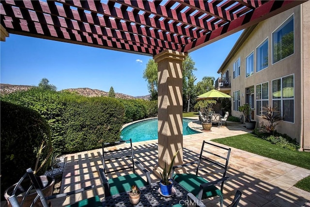 view of patio / terrace with a pergola, a balcony, and a fenced in pool