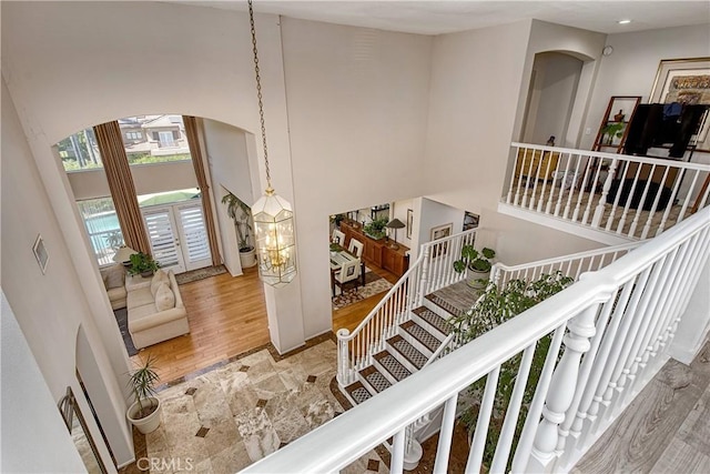 staircase with hardwood / wood-style floors and a towering ceiling