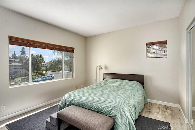 bedroom with light wood-type flooring and multiple windows