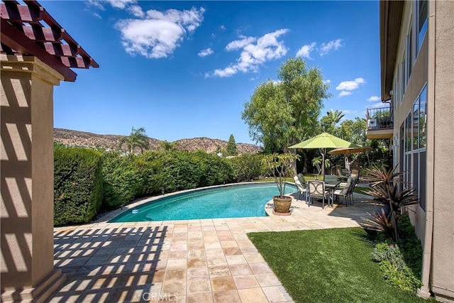 view of swimming pool featuring a patio area and a mountain view