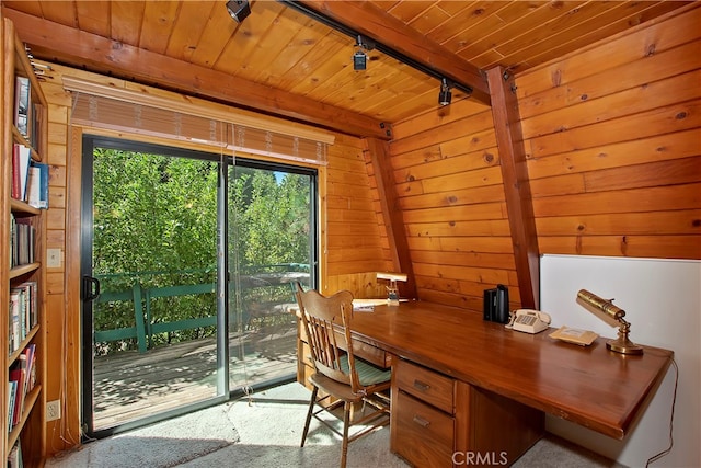 home office featuring rail lighting, wood ceiling, wood walls, beamed ceiling, and light colored carpet