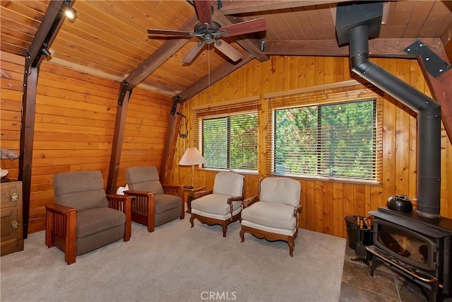sitting room featuring wood ceiling, wood walls, vaulted ceiling with beams, and a wood stove