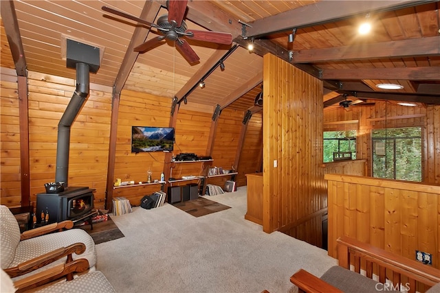 interior space with wooden ceiling, vaulted ceiling with beams, wood walls, and ceiling fan