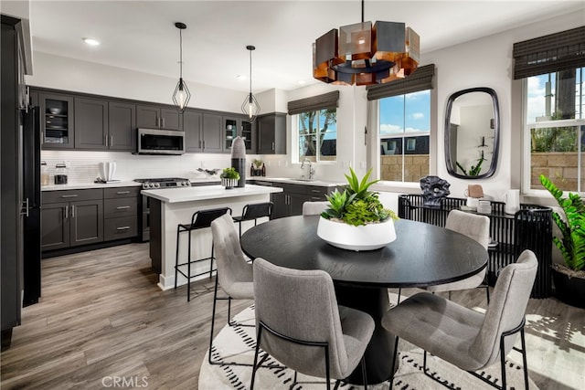 dining room featuring light wood-type flooring, sink, and a wealth of natural light