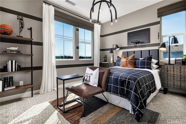 carpeted bedroom with an inviting chandelier