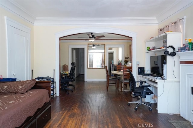 office area featuring built in desk, ceiling fan, dark hardwood / wood-style floors, and crown molding