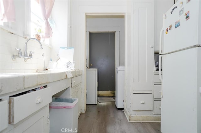 laundry area with light hardwood / wood-style floors and independent washer and dryer