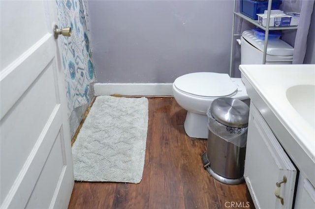 bathroom with hardwood / wood-style floors, vanity, and toilet