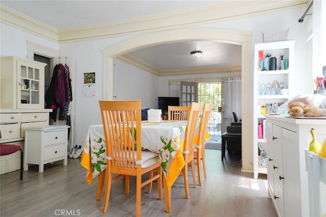 dining room with wood-type flooring and crown molding