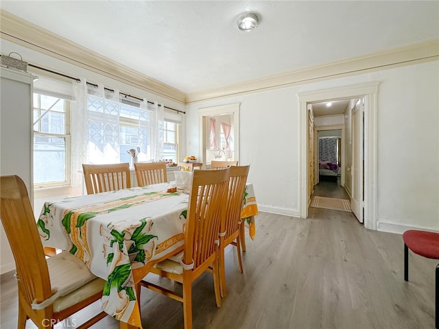 dining space featuring light hardwood / wood-style flooring and ornamental molding