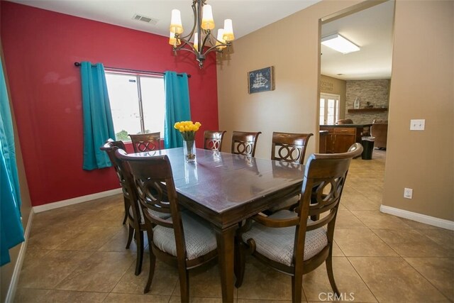 dining area featuring a notable chandelier and light tile patterned flooring