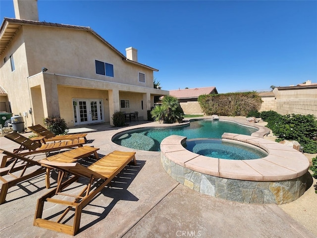 view of pool featuring an in ground hot tub, french doors, and a patio area