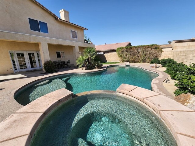 view of pool featuring french doors, a patio, and an in ground hot tub