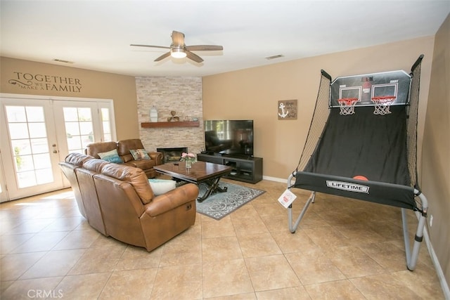 living room with ceiling fan, light tile patterned flooring, a fireplace, and french doors