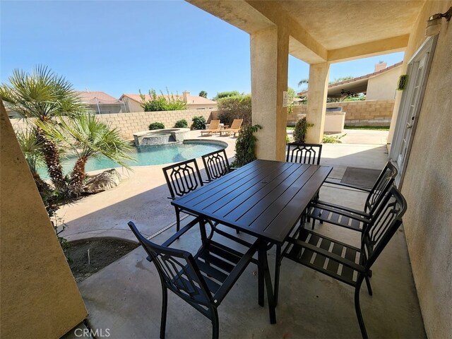 view of patio / terrace with a swimming pool with hot tub