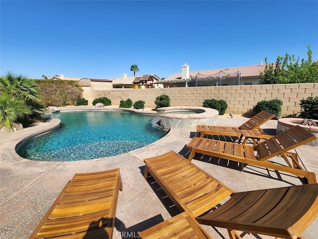 view of pool with an in ground hot tub, pool water feature, and a patio area