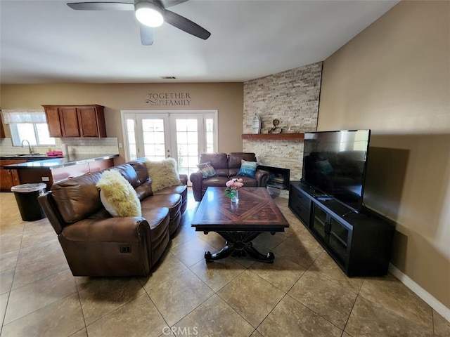 living room featuring light tile patterned floors, ceiling fan, french doors, and sink