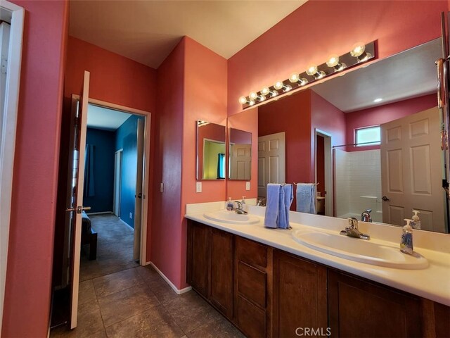 bathroom featuring walk in shower, vanity, and tile patterned flooring