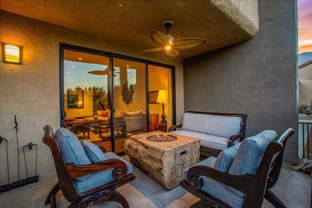 patio terrace at dusk with an outdoor living space with a fire pit and ceiling fan