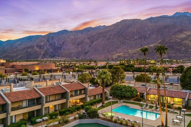 pool at dusk featuring a mountain view