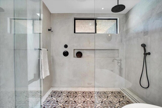 bathroom with a tile shower and tile patterned floors