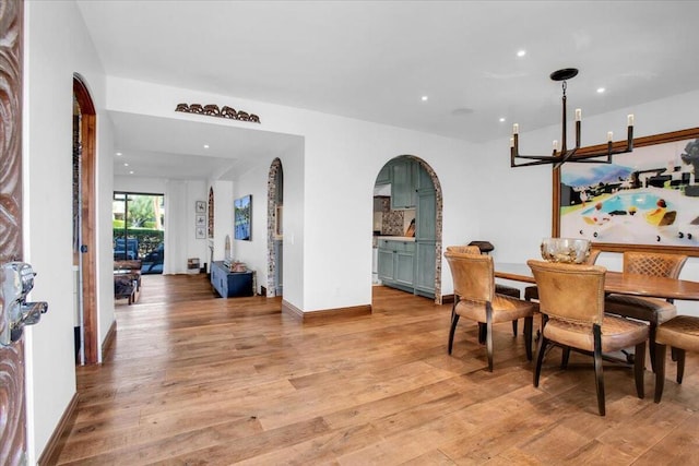 dining area with an inviting chandelier and light hardwood / wood-style floors