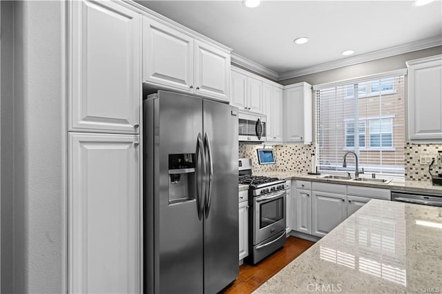 kitchen featuring stainless steel appliances, backsplash, sink, and white cabinetry