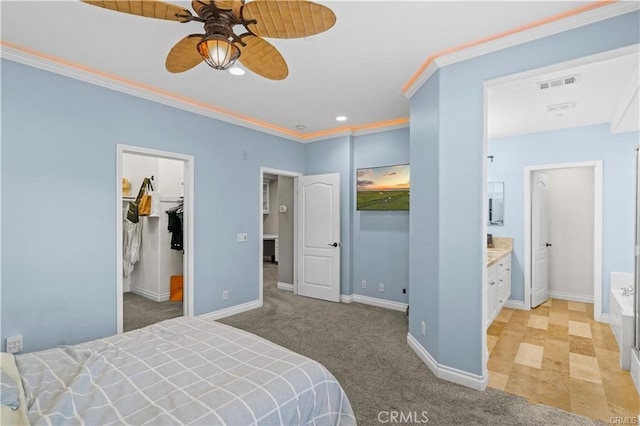 bedroom with ceiling fan, a walk in closet, a closet, light colored carpet, and ensuite bath