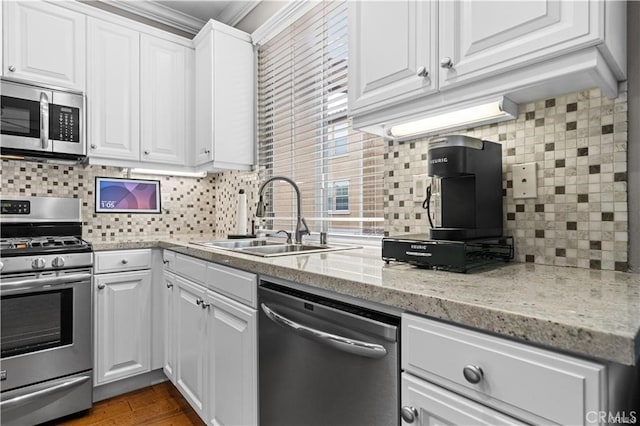 kitchen featuring decorative backsplash, sink, stainless steel appliances, and white cabinets