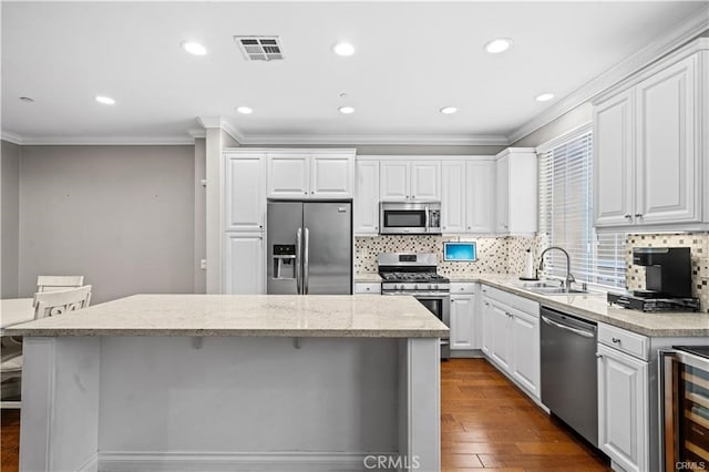 kitchen featuring appliances with stainless steel finishes, a center island, sink, and white cabinets