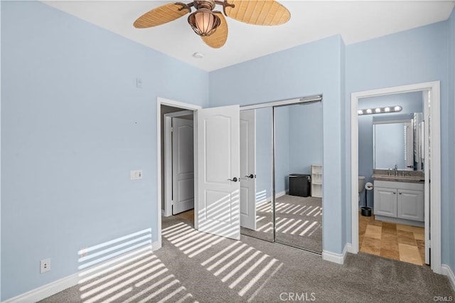 bedroom with ceiling fan, carpet flooring, sink, a closet, and ensuite bathroom