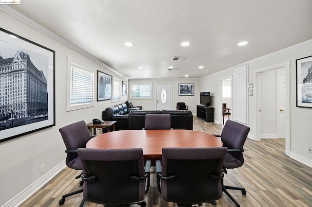 dining room featuring crown molding and light hardwood / wood-style flooring