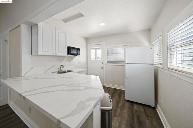 kitchen featuring white refrigerator, white cabinetry, a healthy amount of sunlight, and sink