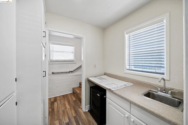 kitchen with dark wood-type flooring, white cabinetry, and sink