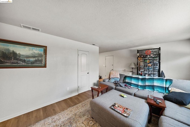 living room featuring a textured ceiling and hardwood / wood-style floors