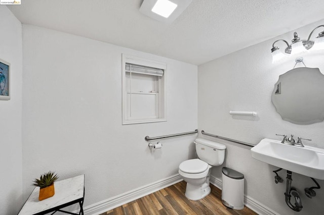 bathroom featuring a textured ceiling, toilet, sink, and hardwood / wood-style flooring