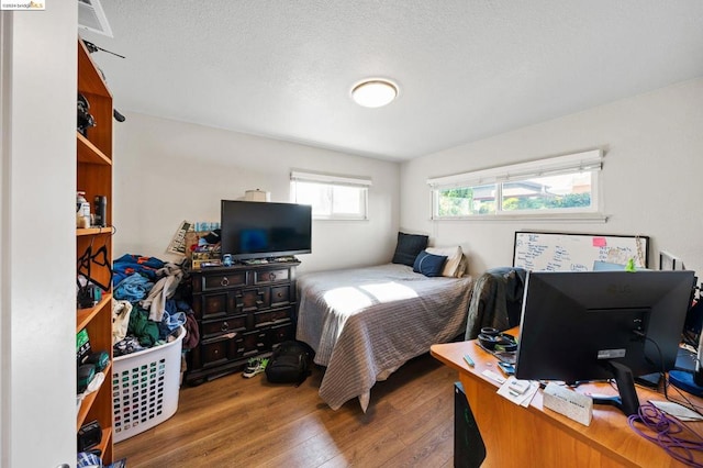 bedroom featuring a textured ceiling and wood-type flooring